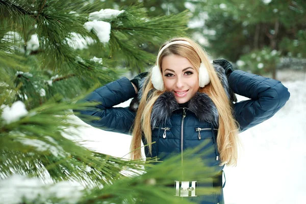 雪に覆われた冬の森の美しい笑顔の少女の肖像画 — ストック写真