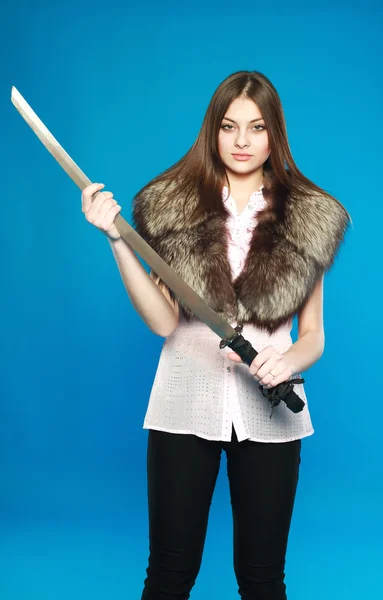 Mladá bruneta stojící s mečem v ruce, v ateliéru na — Stock fotografie