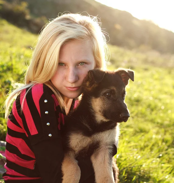 Dospívající dívka drží německý ovčák štěně venku, podsvícený — Stock fotografie