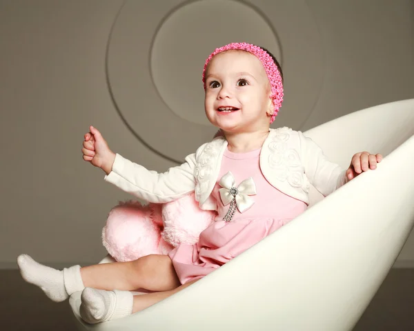 Happy smiling baby infant in the studio, on a white chair — Stock Photo, Image