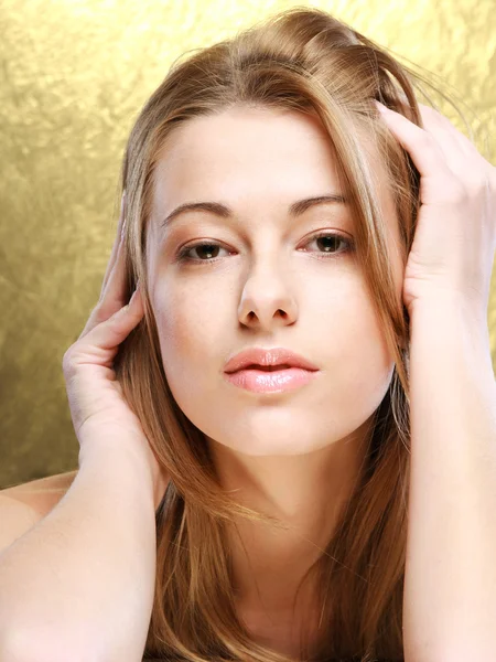 Close-up portrait of beautiful girl, studio, on a gold backgroun — Stock Photo, Image