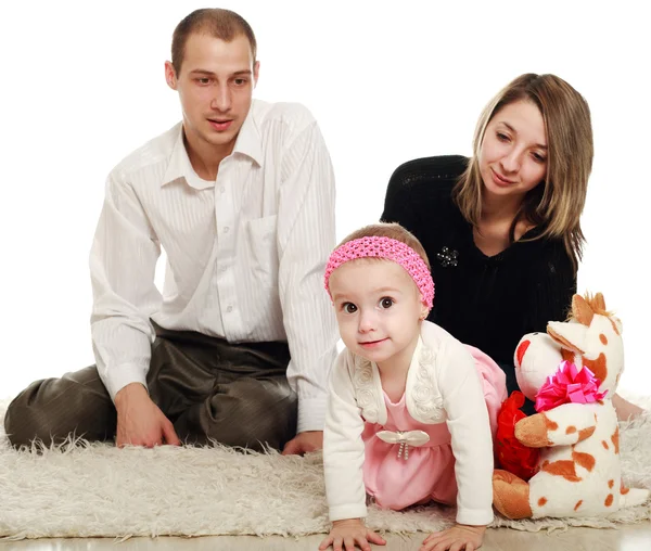 Los padres jóvenes y el bebé, en el estudio sobre un fondo blanco — Foto de Stock