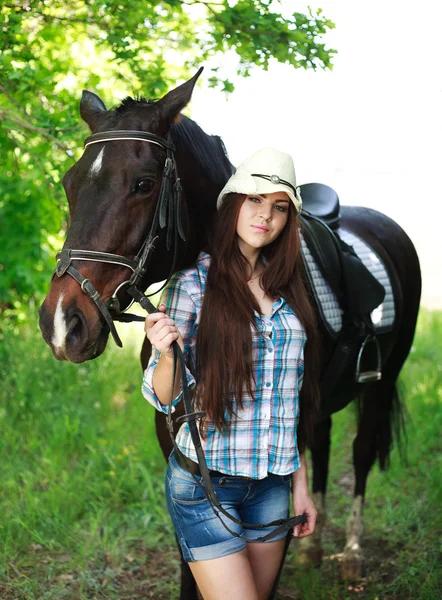 Outdoor portrait of beautiful cowgirl with horse in green — Stock Photo, Image