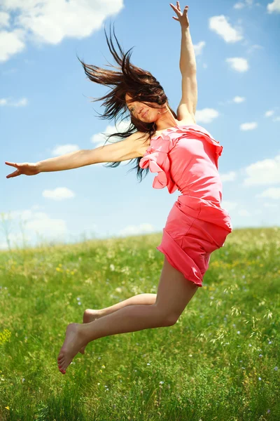 Saltando e voando menina graciosa no fundo do céu azul — Fotografia de Stock