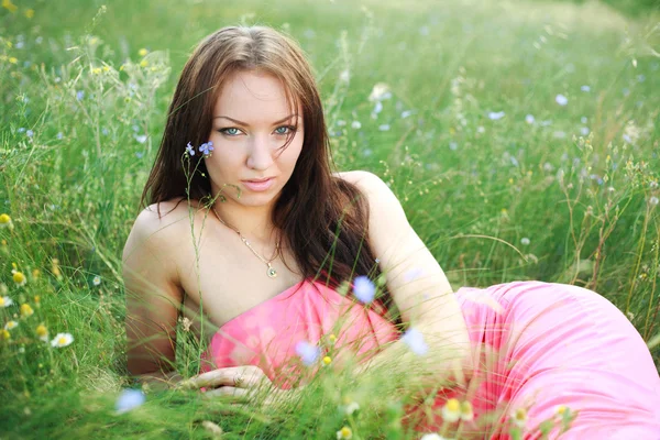 Güzel genç kız dreams, çayır üzerinde yeşil çim yalan söylüyor. — Stok fotoğraf