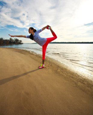 genç kadın ince, egzersiz kumsalda güneş doğarken