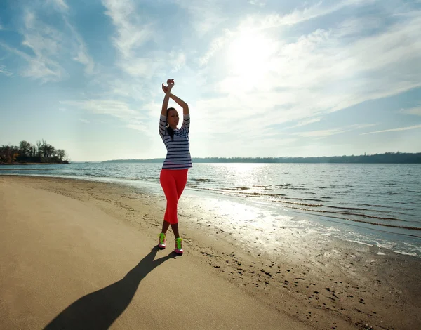 Mujer delgada joven, ejercicio en la playa al amanecer — Foto de Stock
