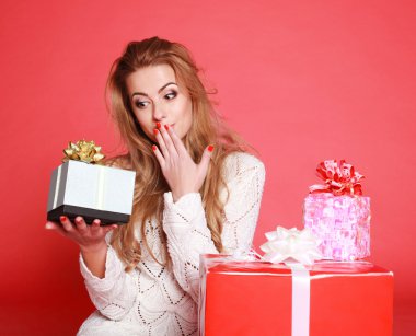 genç gülümseyen kadın hediye, stüdyo pembe üzerinde tutarak sürpriz yaptı.