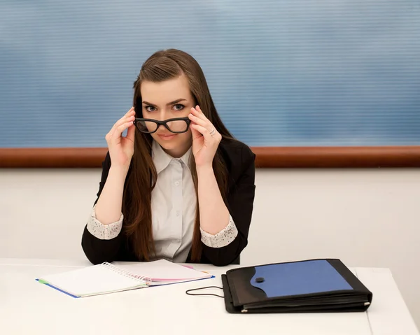 Young teacher in the class works at a table — Stock Photo, Image