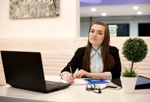 Jovem mulher de negócios trabalhando no escritório com um laptop — Fotografia de Stock