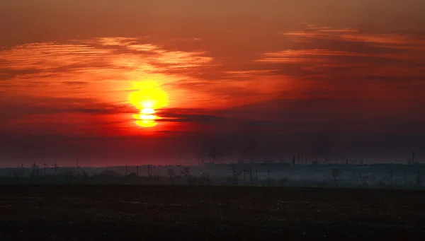 Industriestadt im schmutzigen Rauch vor dem Hintergrund des Sonnenuntergangs — Stockfoto