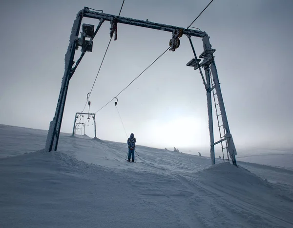 눈덮인 꼭대기에서 스키를 산비탈을 올라가는데 지평선 너머로 — 스톡 사진