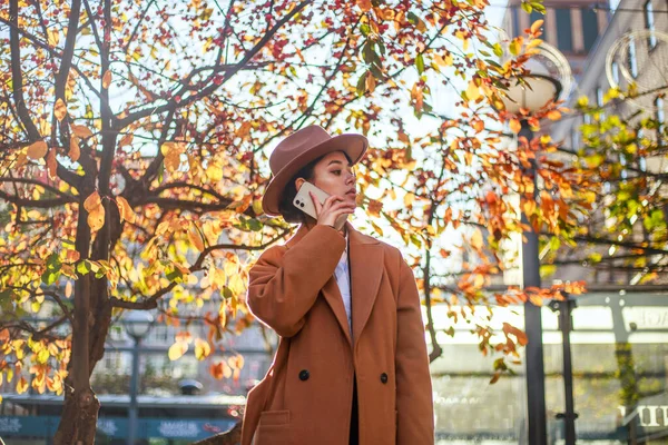 Young Asian Lady Beige Coat Hat Calls Mobile Phone City — ストック写真