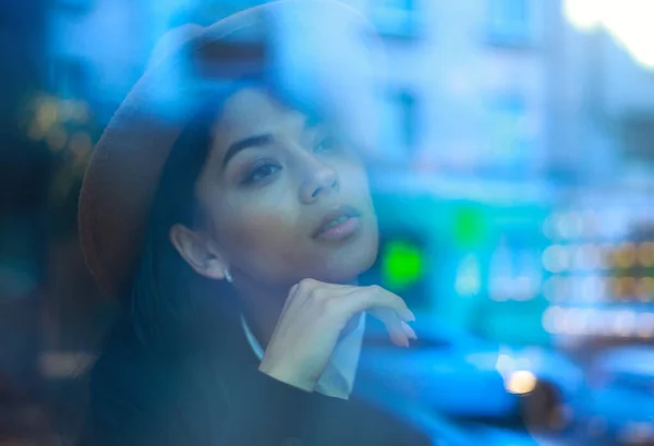 古典的なビジネススタイルの若いアジアの女性は コーヒーを飲みながら通りやライトの反射で窓を透過して座っています — ストック写真