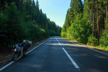 Asfalt boş yol kozalaklı dağlarda, gezgin bisikleti yol kenarında, özgürlük ve yolculuk konsepti