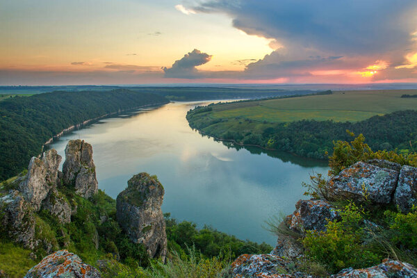 Пейзаж над рекой и древние мистические скалы на фоне величественного неба, Днестровского залива, природы Украины