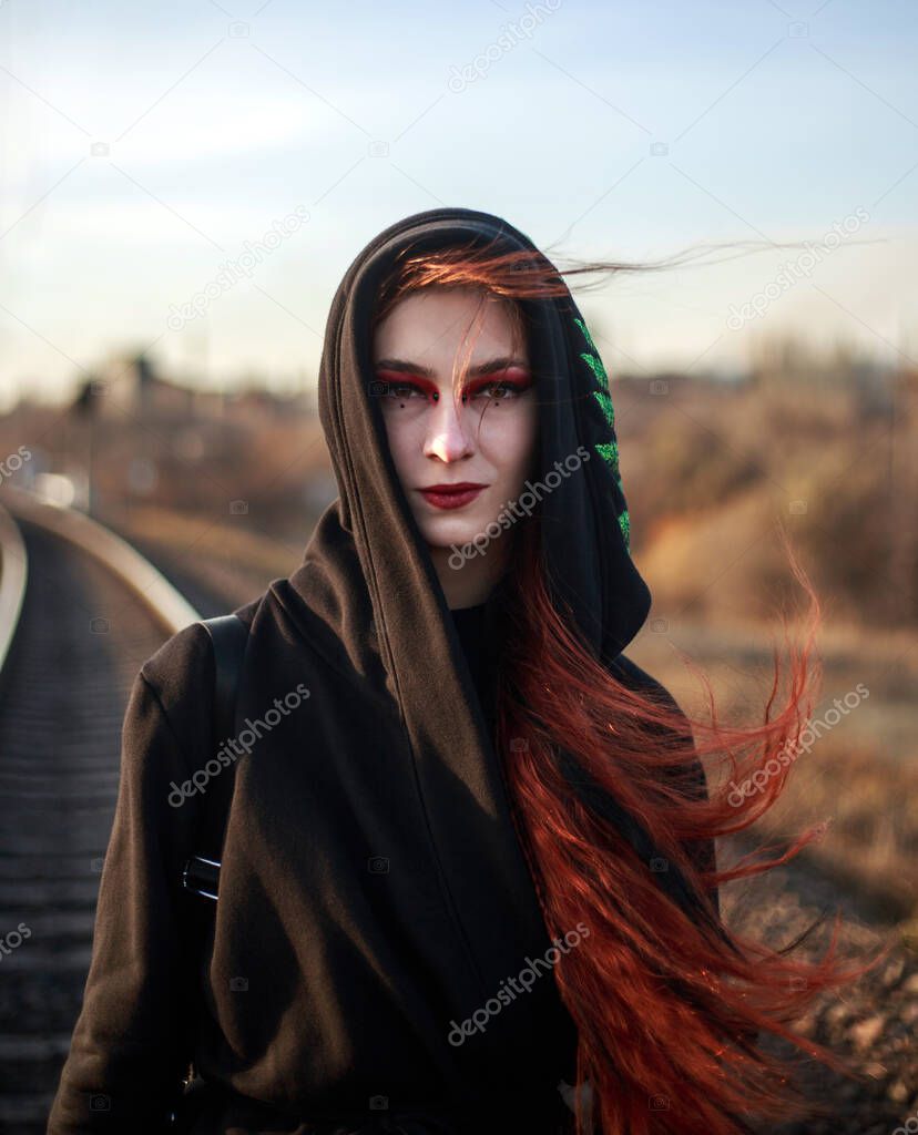 Young lonely woman walking along a railway track, on the background of an industrial city, despair and depression portrait,  in dramatic and anti-utopia style
