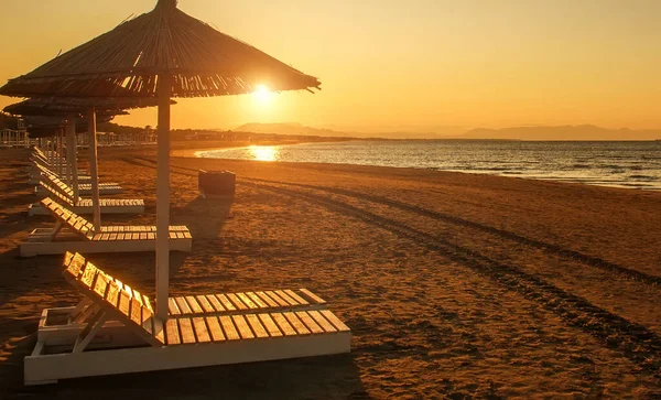 Beach Loungers Empty Sand Coast Sea Bright Sunset Light Montenegro lizenzfreie Stockfotos