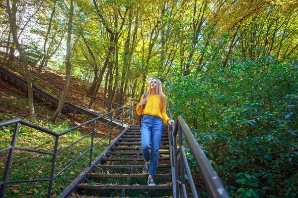 バックパックを持った若い女性が市内の森林公園を歩き 秋の晴れた日に自然を楽しむ — ストック写真