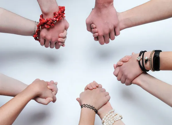 The clasped hands of young people, a gesture of community ...