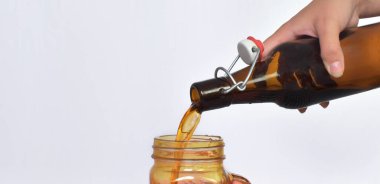 Beyaz arka planda bir kavanoza sıvı dökülüyor. ... 