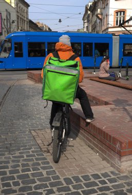 Bisikletli bir kurye şehre yiyecek getiriyor. ...