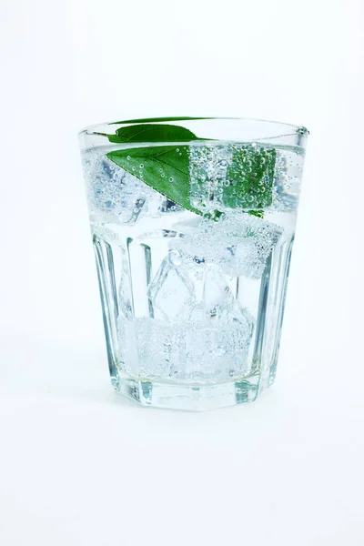 Ένα Ποτήρι Νερό Πάγο Και Ένα Πράσινο Φύλλο — Φωτογραφία Αρχείου