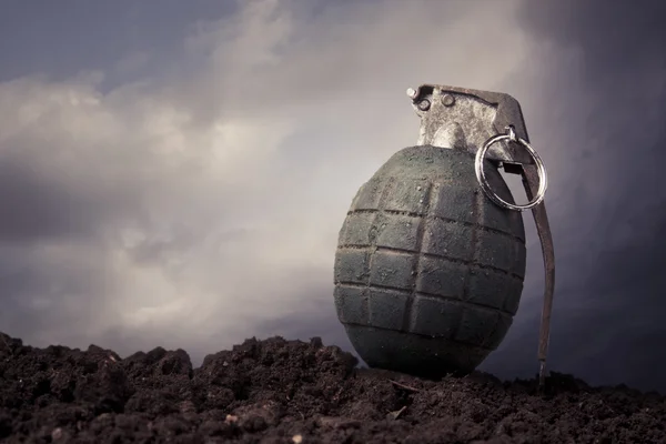 Green grenade on a battlefield at dusk — Stock Photo, Image