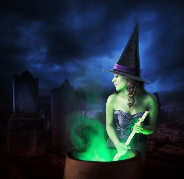 Witch with her cauldron on Halloween night — Stock Photo, Image