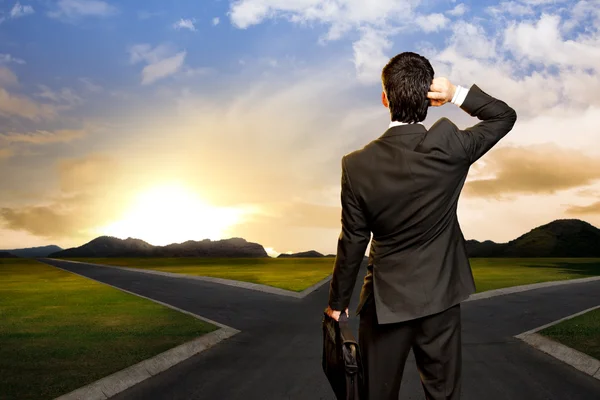 Young businessman in front of a crossroad — Stock Photo, Image