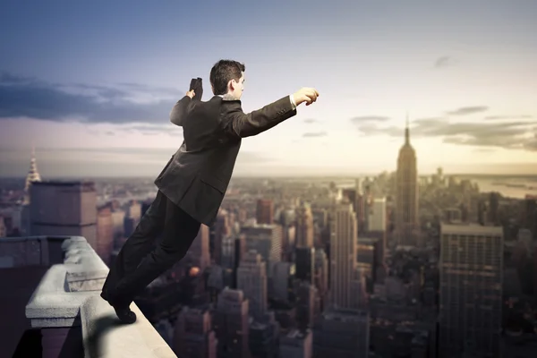 Businessman standing with open arms on top of NY city — Stock Photo, Image