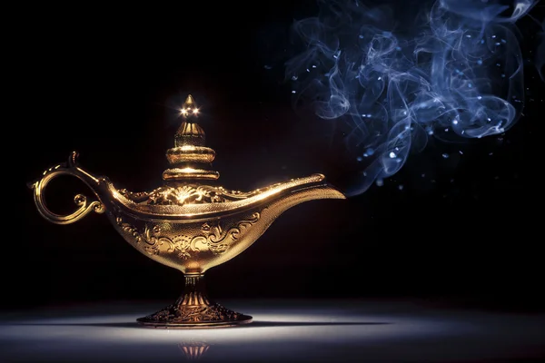 Magic Aladdin 's Genie lamp on black with smoke Стоковое Изображение