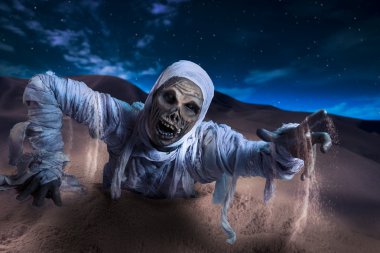 Scary mummy in a desert at night clipart