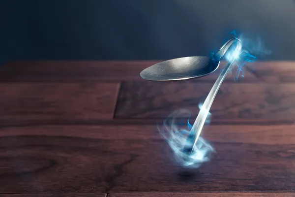 Psychokinesis concept with bent spoon — Stock Photo, Image