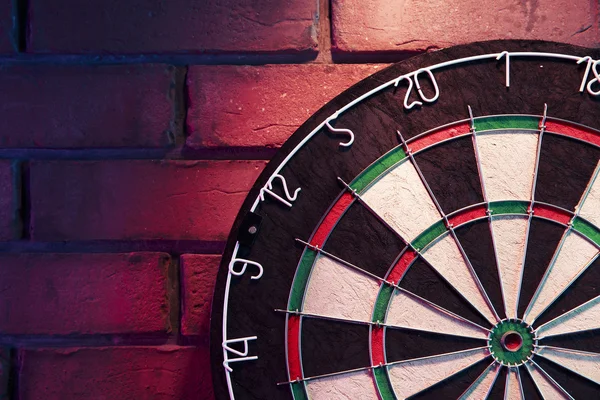 Dartboard em uma parede de tijolo — Fotografia de Stock