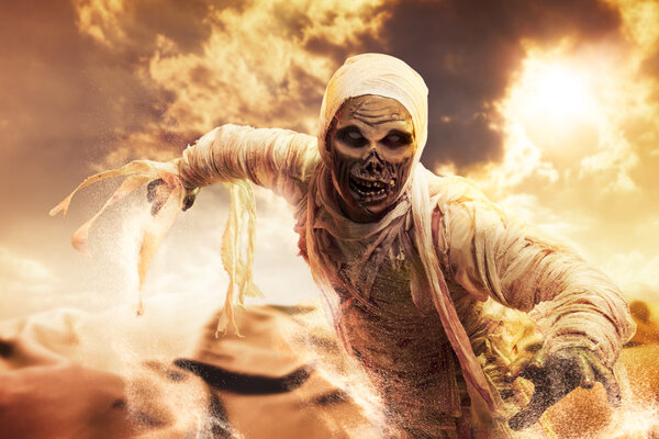 Страшная мумия в пустыне на закате
