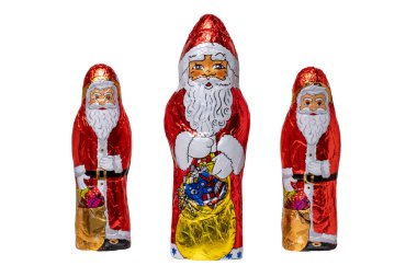 Çikolatalı Noel Baba izole edilmiş. Üç neşeli çikolatalı Noel Baba 'ya yakın plan mı yoksa beyaz arka planda izole edilmiş Aziz Nicolas heykelciğine mi? Makro fotoğraf.