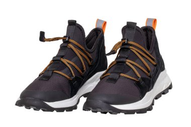 Closeup of a pair of modern black sneakers or sports shoes isolated on a white background. Clipping path. Elegant and trendy mans shoes. Macro.