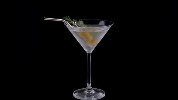 Alcohol cocktail with rosemary and green olives on a black background. — Stock Video