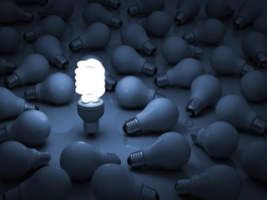 One glowing eco compact fluorescent light bulb standing out from the unlit incandescent light bulbs clipart