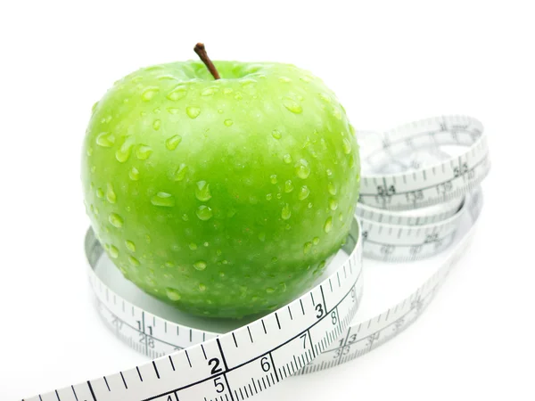 Зеленое яблоко и измерительная лента на белом фоне — стоковое фото