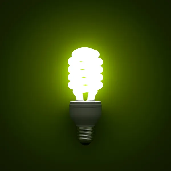 Lampadina fluorescente compatta a risparmio energetico incandescente su sfondo verde — Foto Stock