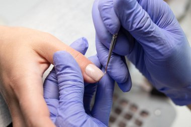 Bir kaplıca salonunda manikür yapma süreci. Manikürcü kuaförde tırnaklarına jöle sürmüş. Jel cilası sürüyorum. El bakımı kavramı.