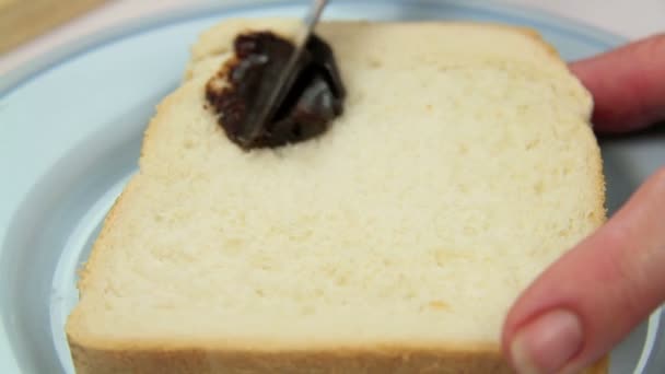 Vegemite being spread on to a slice of fresh bread — Stock Video