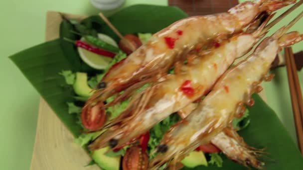 Trois crevettes brochées poussées en gros plan sur une salade 