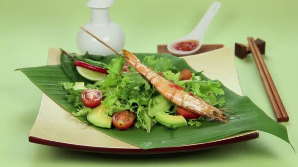 Deitado deliciosos camarões asiáticos espetados em uma cama de salada fresca . — Vídeo de Stock