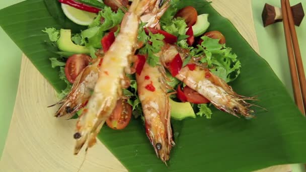 Colocando espetos camarões asiáticos em uma cama de salada de jardim . — Vídeo de Stock