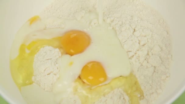Close up pouring milk and melted butter on to eggs in a cake mix. — Stock Video