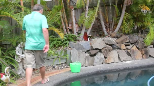 Un hombre sale de la piscina — Vídeos de Stock