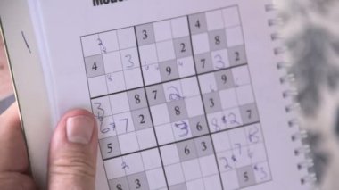 kalemle .sudoku oynayarak kişi.